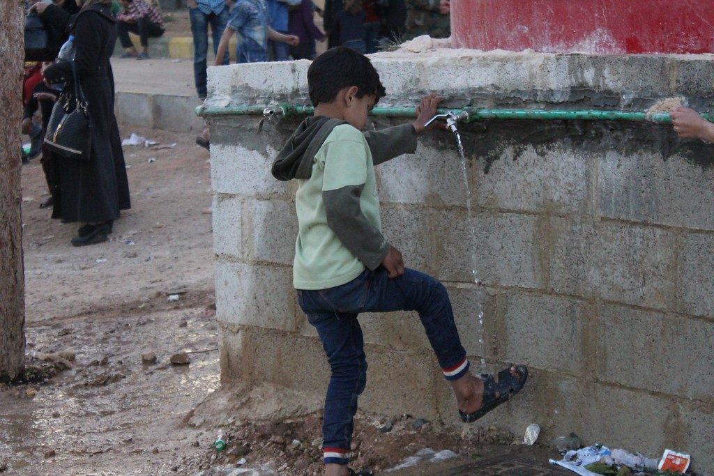 Boy washes his feet at a collective shelter for IDPs from eastern Ghouta. ©OCHA/Ghalia Seifo